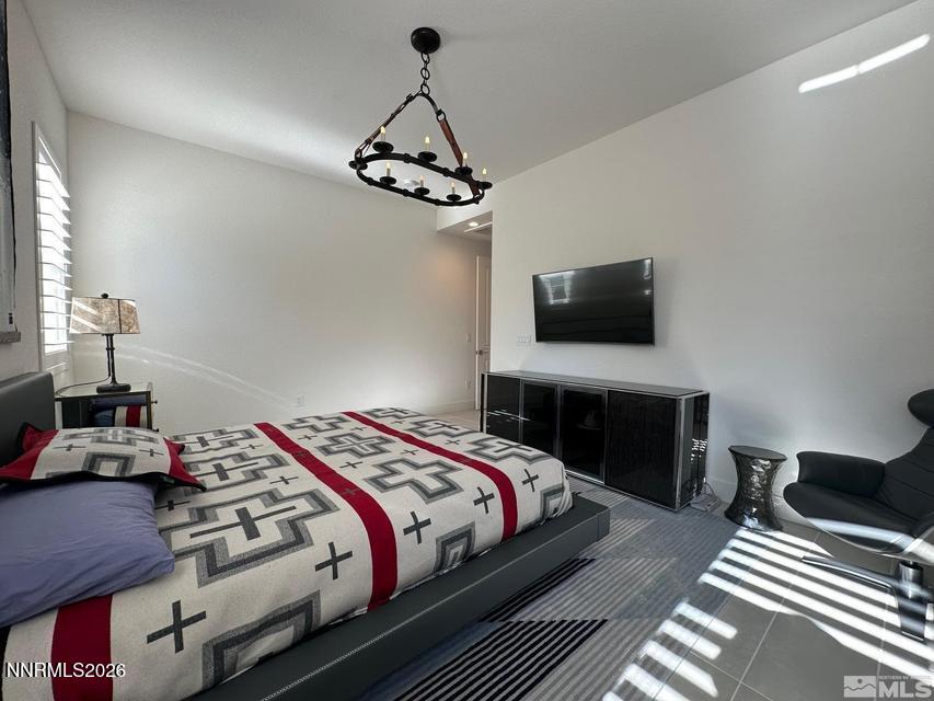 5545 Western Rider Trail Reno, NV 89511 - Photo 30 of 37 a bedroom with a bed and a chandelier