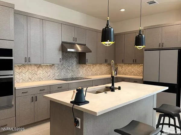 a kitchen with stainless steel appliances granite countertop a sink a refrigerator and a stove