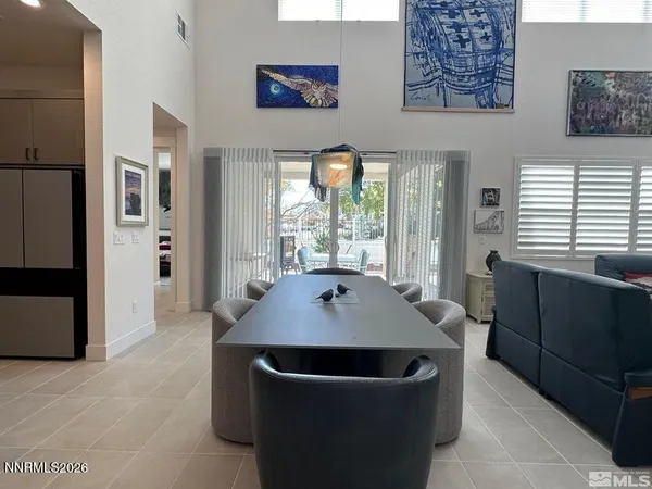 a dining room with wooden floor and large windows