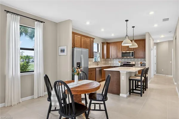 a kitchen with kitchen island a dining table and chairs
