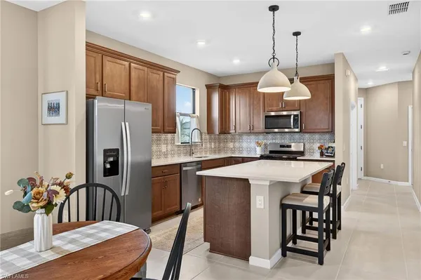 a kitchen with refrigerator a sink and a wooden cabinets