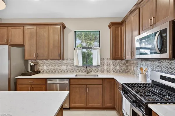 a kitchen with stainless steel appliances a stove sink microwave and cabinets