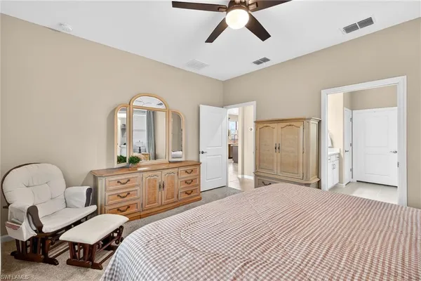 a bedroom with a bed a chandelier and dresser