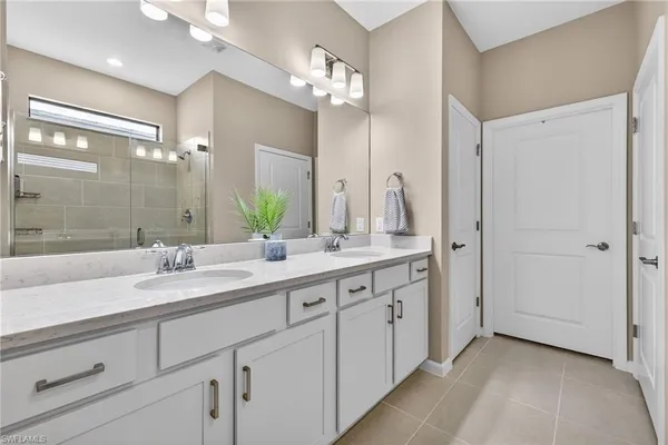 a spacious bathroom with a granite countertop sink a mirror and a shower