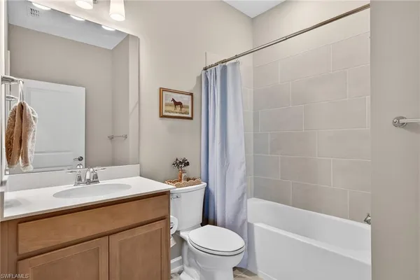 a bathroom with a sink a toilet a mirror a shower and a bathtub