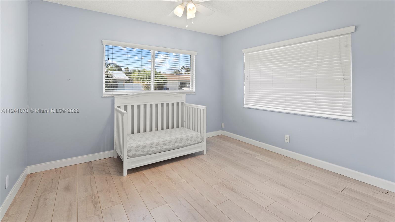 3166 Northwest 68th Court Fort Lauderdale, FL 33309 - Photo 17 of 36 a view of an empty room with wooden floor and a window