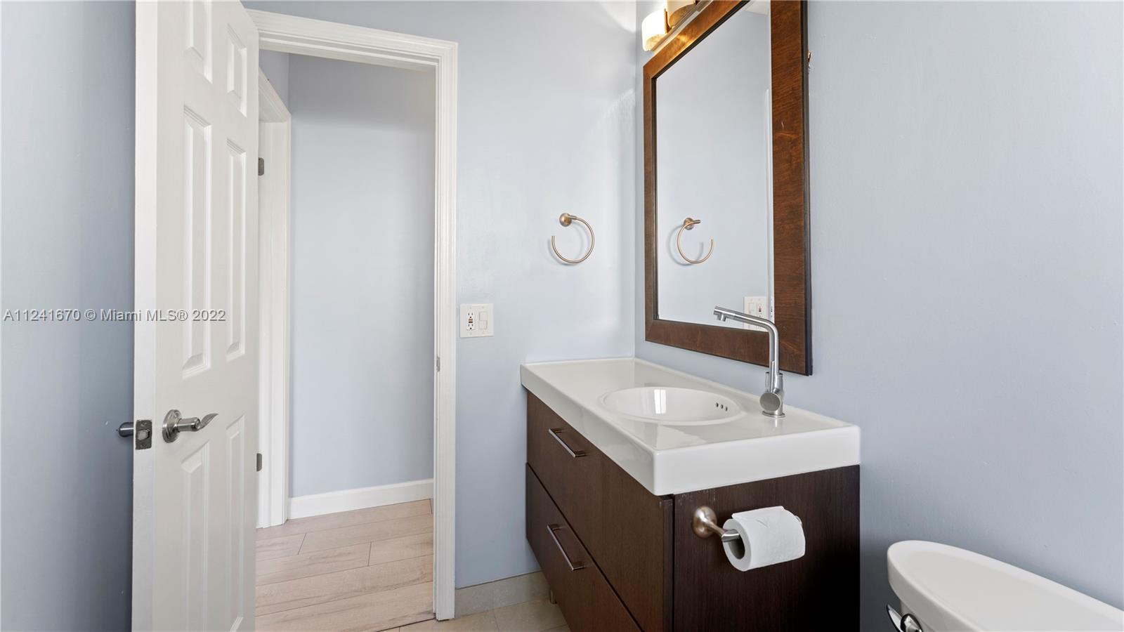 3166 Northwest 68th Court Fort Lauderdale, FL 33309 - Photo 19 of 36 a bathroom with a sink vanity mirror and toilet