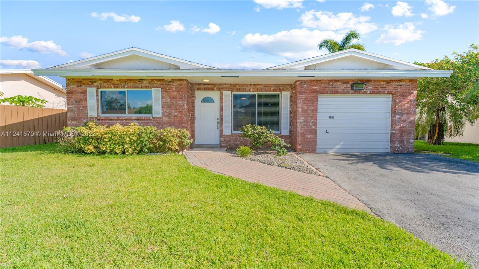 3166 Northwest 68th Court Fort Lauderdale, FL 33309 - Photo 2 of 36 a front view of a house with garden