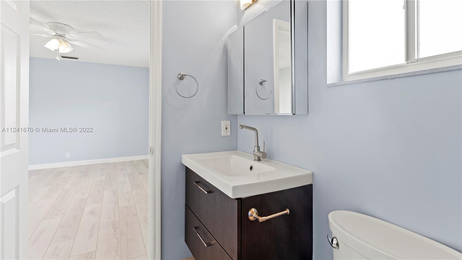 3166 Northwest 68th Court Fort Lauderdale, FL 33309 - Photo 23 of 36 a bathroom with a sink a toilet and vanity
