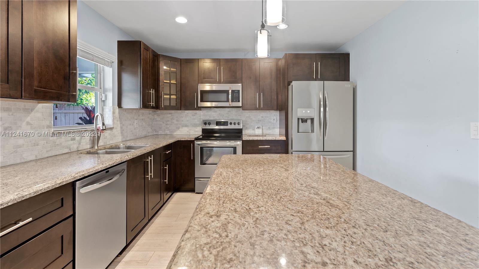3166 Northwest 68th Court Fort Lauderdale, FL 33309 - Photo 25 of 36 a large kitchen with cabinets and stainless steel appliances