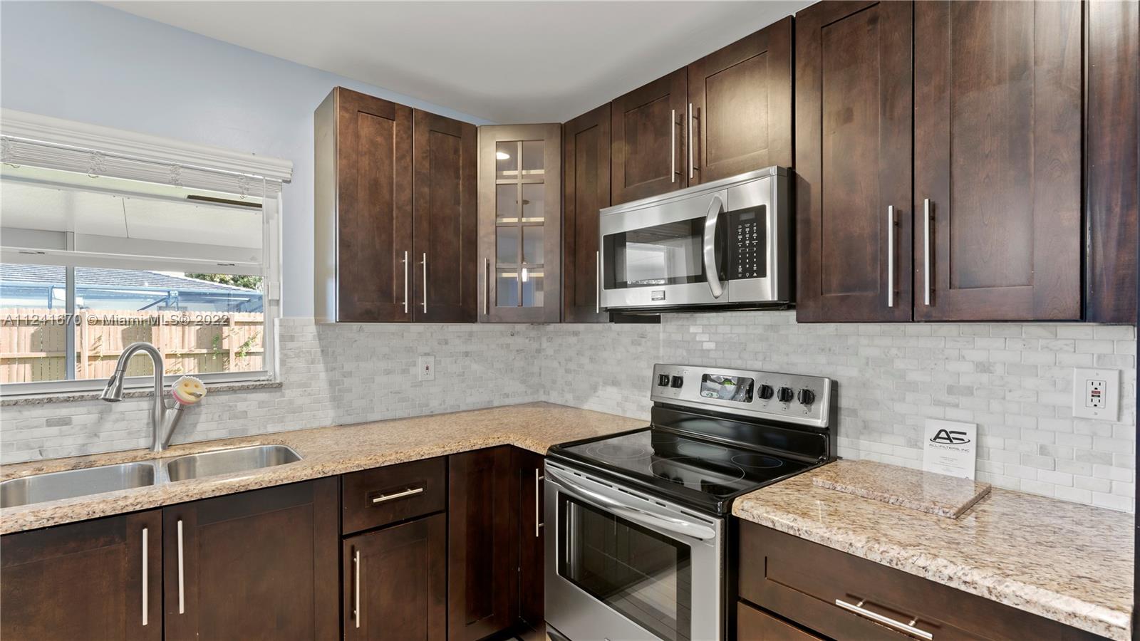 3166 Northwest 68th Court Fort Lauderdale, FL 33309 - Photo 27 of 36 a kitchen with granite countertop cabinets stainless steel appliances and a sink