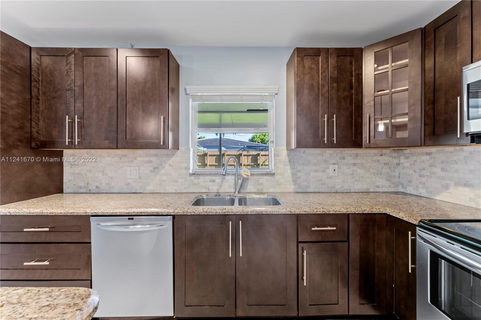 3166 Northwest 68th Court Fort Lauderdale, FL 33309 - Photo 29 of 36 a kitchen with a sink and a microwave