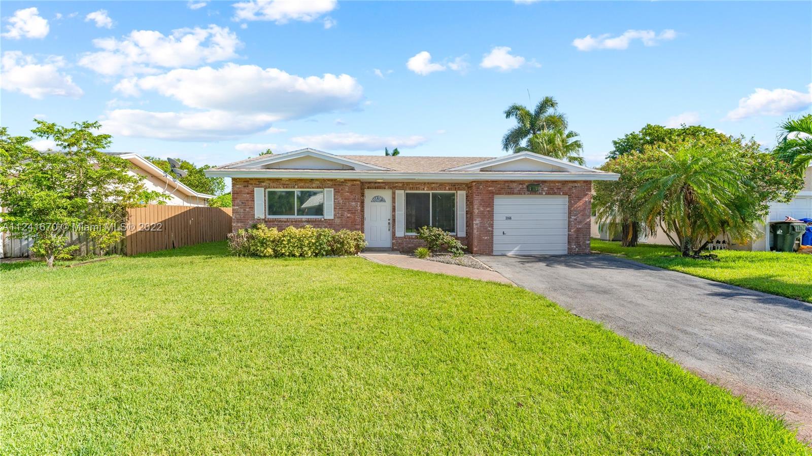 3166 Northwest 68th Court Fort Lauderdale, FL 33309 - Photo 6 of 36 a front view of a house with garden