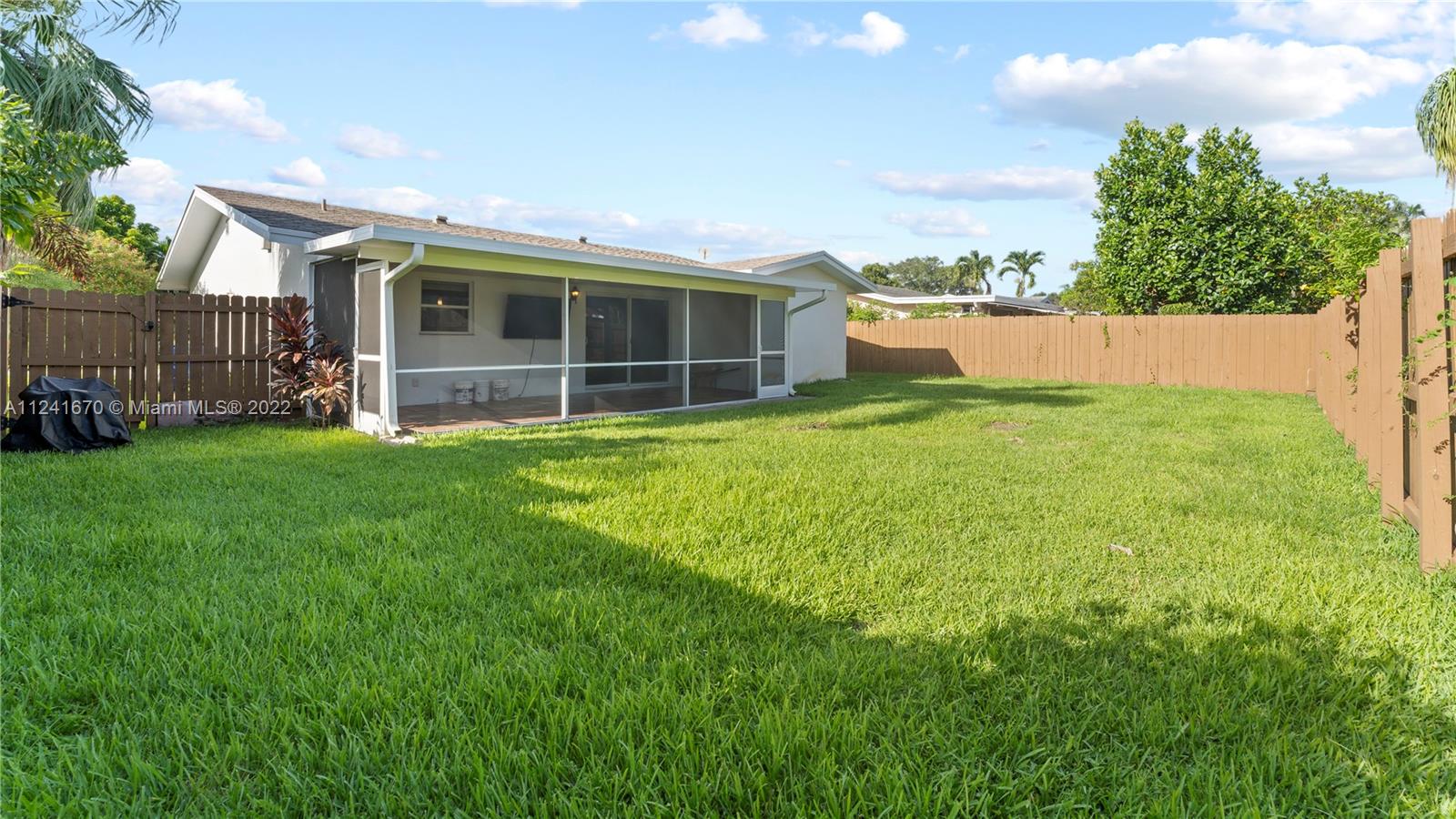 3166 Northwest 68th Court Fort Lauderdale, FL 33309 - Photo 8 of 36 a view of a backyard with plants and large trees