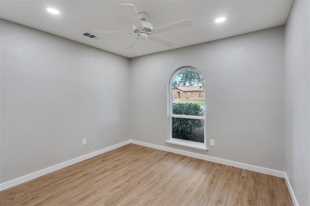 516 Ridgemont Drive Allen, TX 75002 - Photo 13 of 25 an empty room with wooden floor chandelier fan and windows