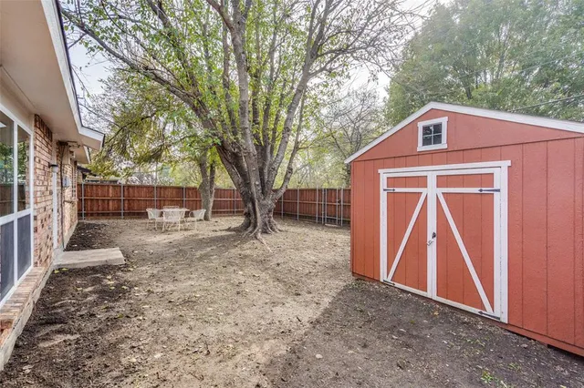 a view of a house with a yard and large tree