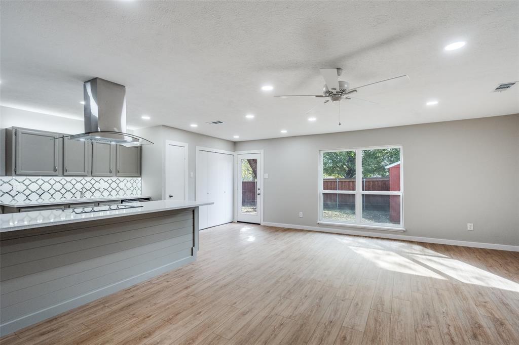 516 Ridgemont Drive Allen, TX 75002 - Photo 7 of 25 an empty room with a wooden floor and chandelier