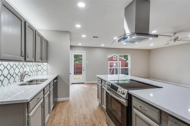 a kitchen with stainless steel appliances granite countertop a sink stove and cabinets