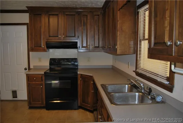 a kitchen with granite countertop a sink and a stove top oven