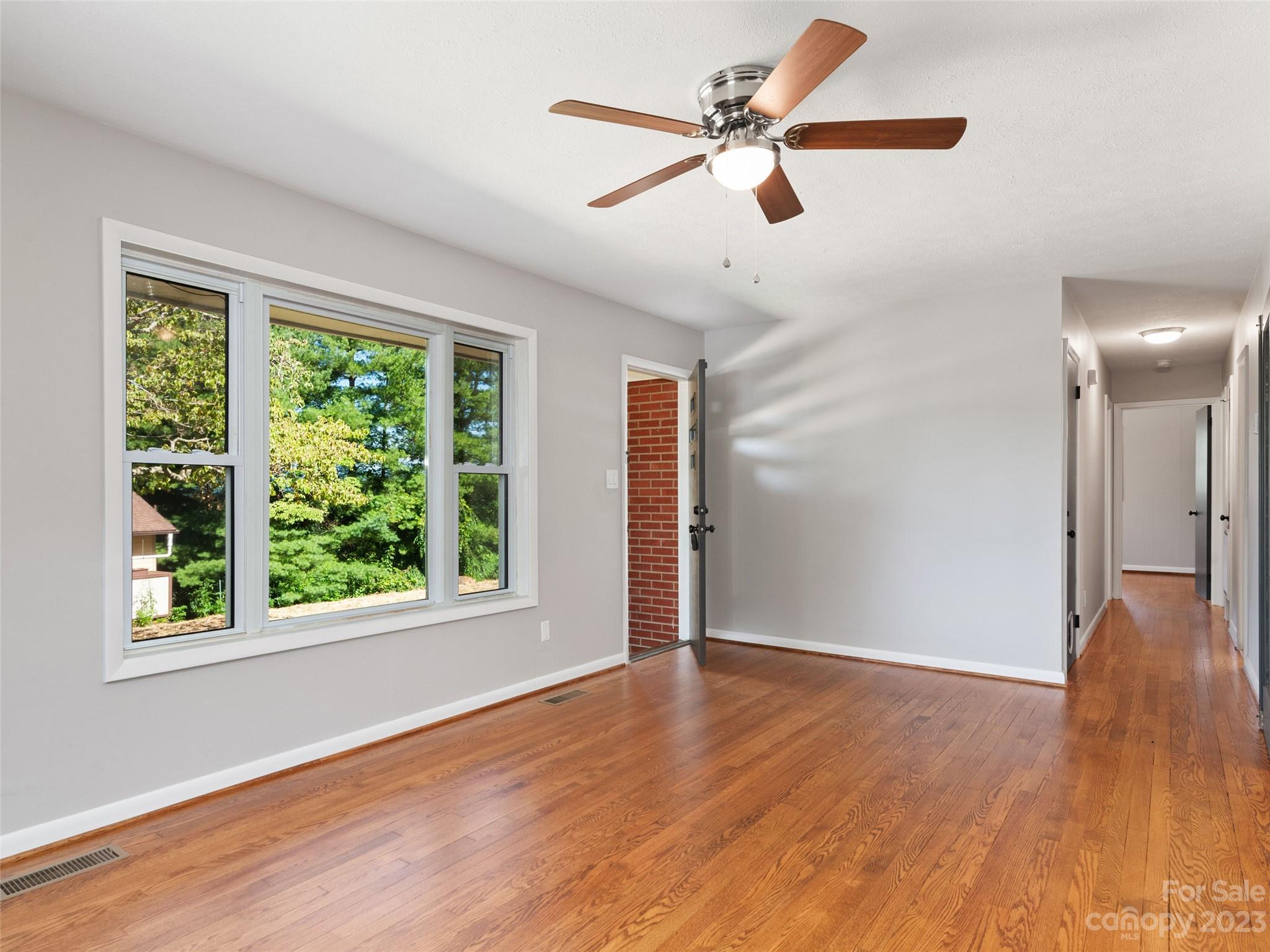 79 Oak Street Clyde, NC 28721 - Photo 3 of 23 a view of an empty room with wooden floor and a window