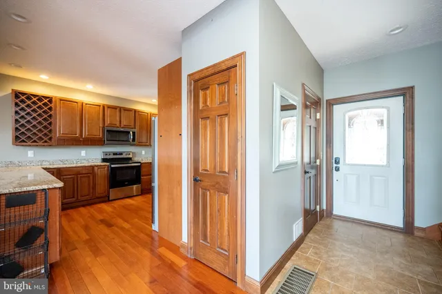 a view of a livingroom with a flat screen tv wooden floor and a ceiling fan