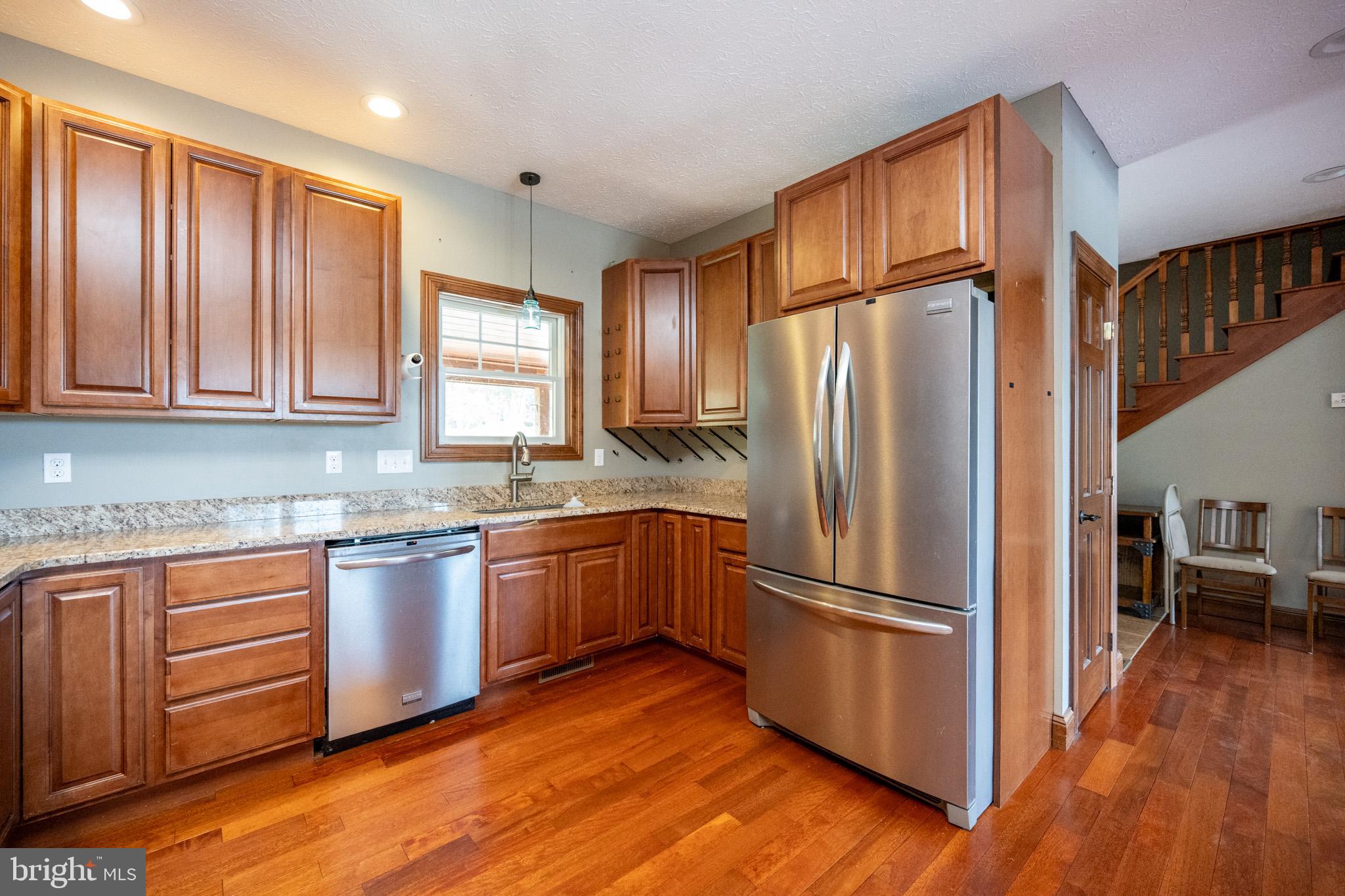 1909 Pysell Crosscut Road Oakland, MD 21550 - Photo 15 of 82 a kitchen with granite countertop stainless steel appliances a refrigerator cabinets and wooden floor