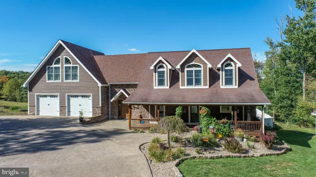 a view of a livingroom with a flat screen tv ceiling fan and hardwood floor