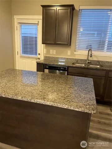 a kitchen with kitchen island sink granite counter tops and a window