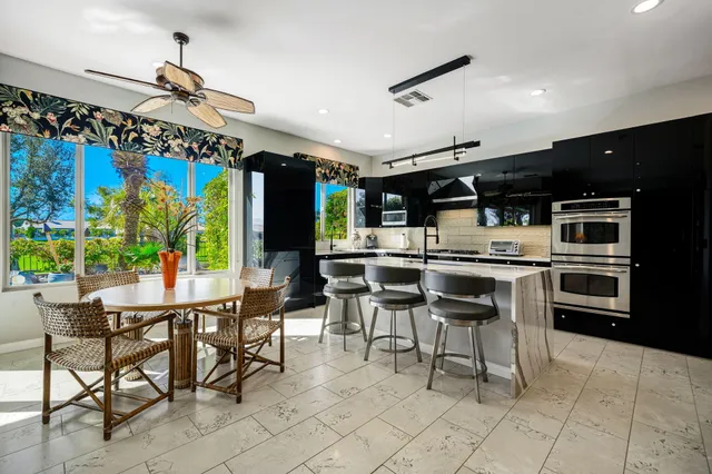 a kitchen with stainless steel appliances kitchen island granite countertop a sink and a stove