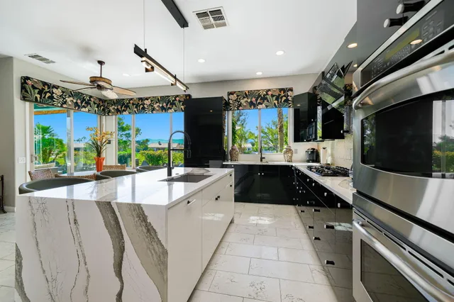 a view of a backyard with couches plants and large trees