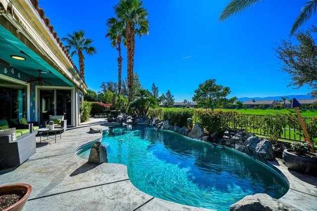 a front view of a house with swimming pool having outdoor seating