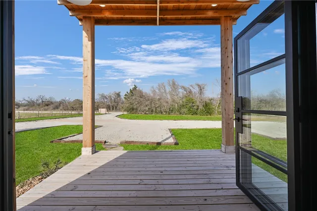 a view of a porch with a floor to ceiling window next to a yard