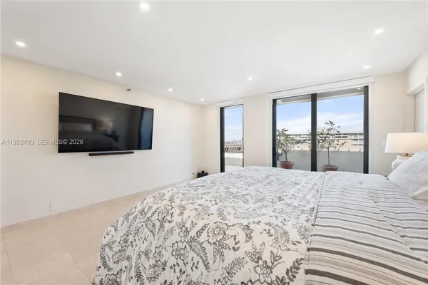 a bedroom with a large bed and a flat screen tv