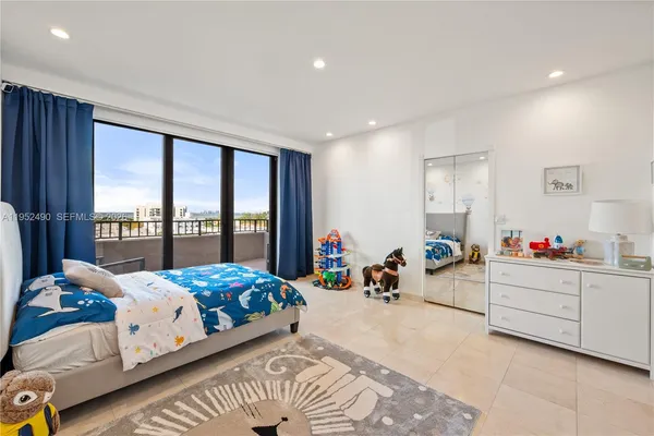 a bedroom with a bed and large windows