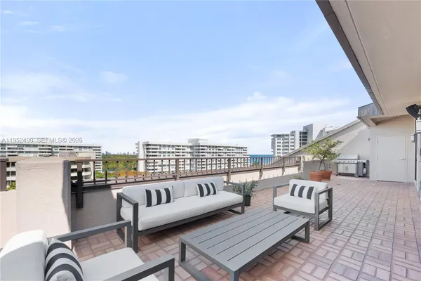 a roof deck with couches and wooden floor