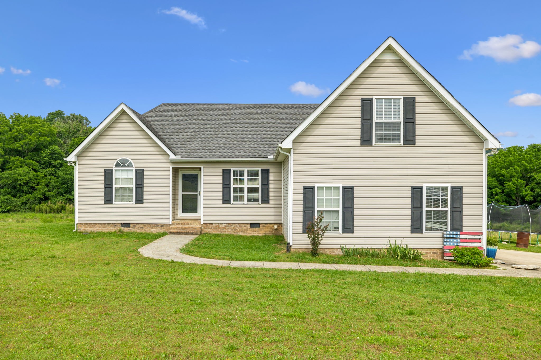 a front view of house with yard and green space