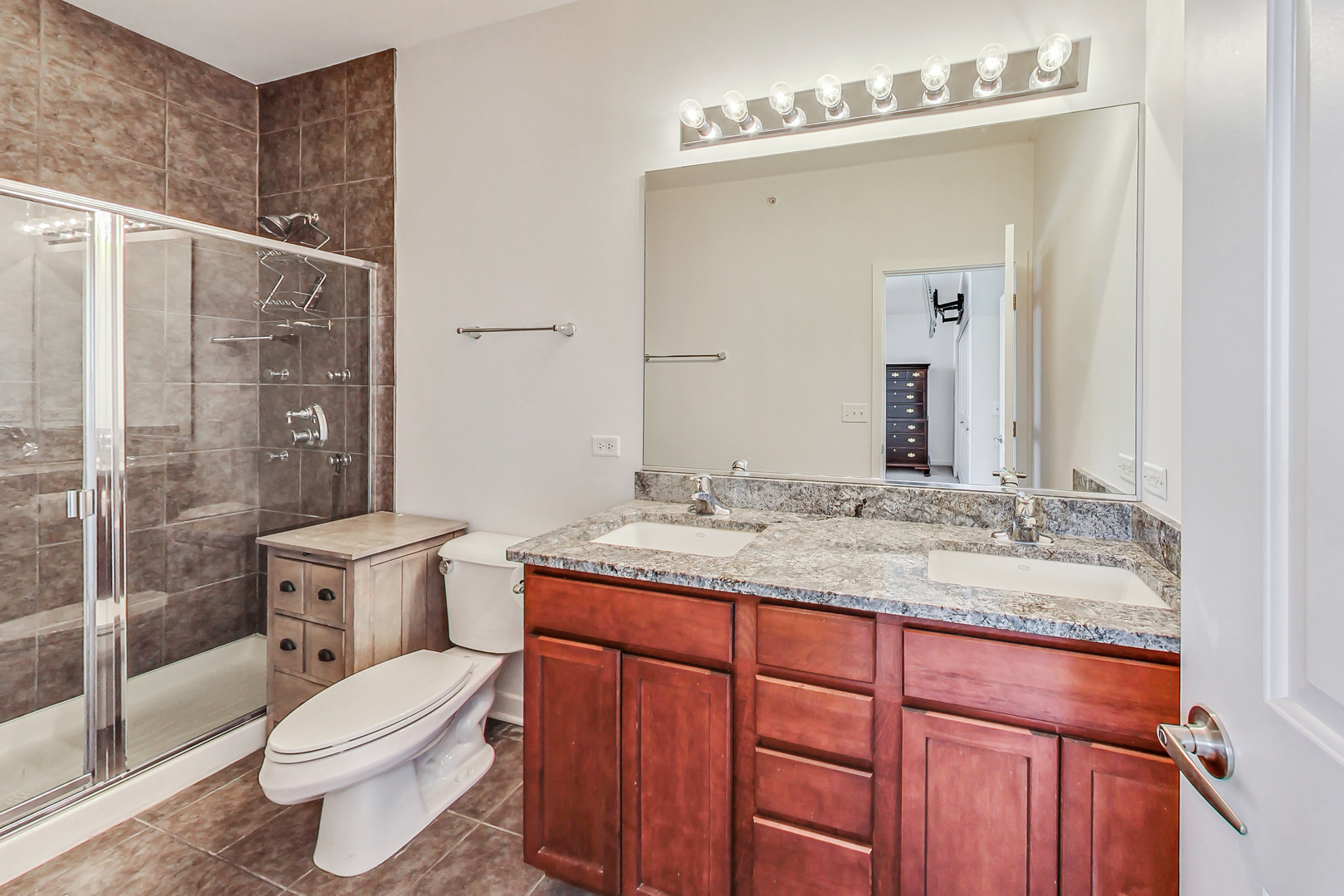 45 East 23rd Street Chicago, IL 60616 - Photo 15 of 27 a bathroom with a granite countertop sink toilet a mirror and shower