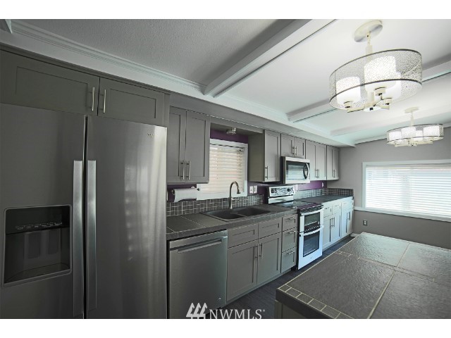 2500 South 370th Street, Unit 12 Federal Way, WA 98003 - Photo 16 of 40 a kitchen with stainless steel appliances granite countertop a sink a stove and refrigerator