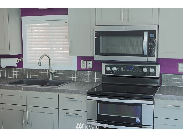 2500 South 370th Street, Unit 12 Federal Way, WA 98003 - Photo 17 of 40 a kitchen with microwave a stove and cabinets