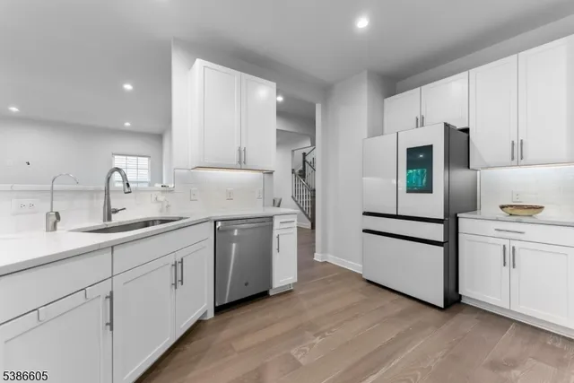 a kitchen with granite countertop white cabinets and white appliances