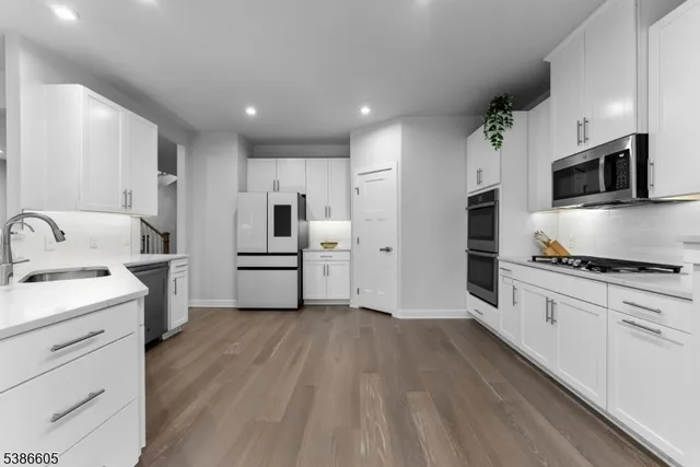 a kitchen with granite countertop a refrigerator and a stove top oven