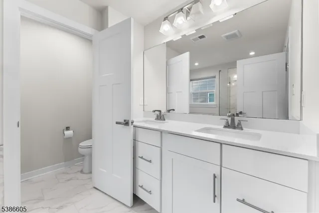 a bathroom with a double vanity sink and a toilet