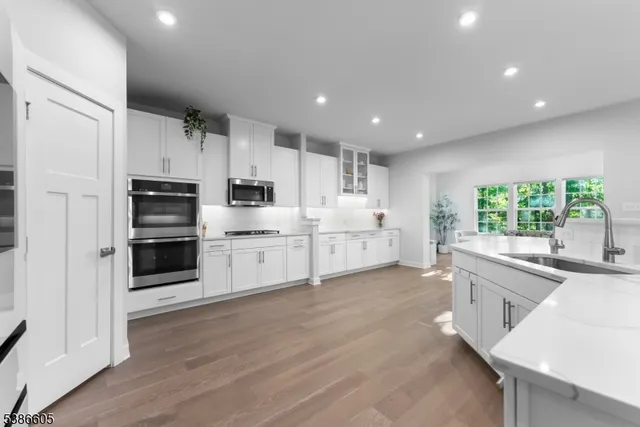 a large kitchen with stainless steel appliances kitchen island granite countertop a stove and a refrigerator