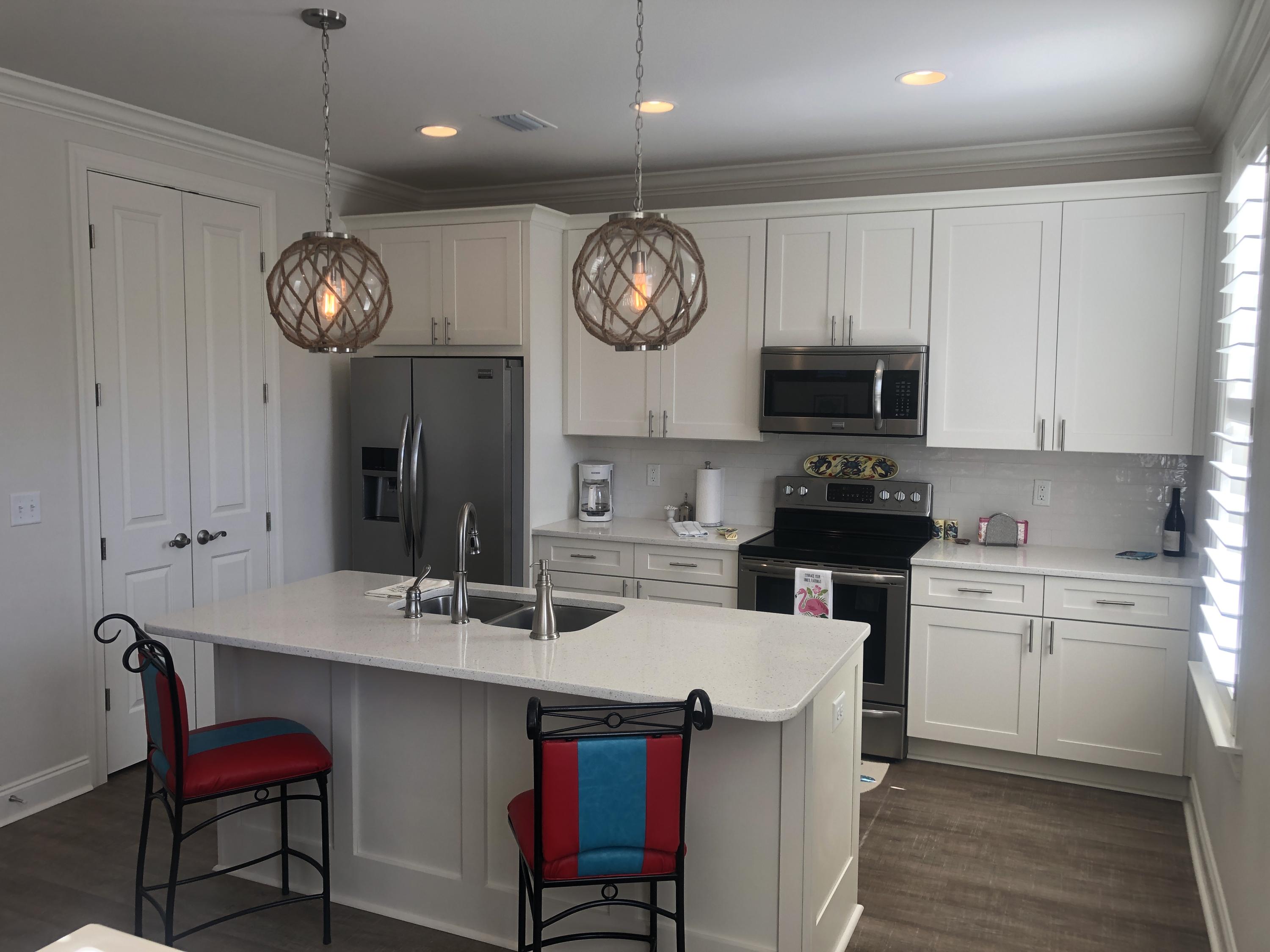 52 Chapman Street Santa Rosa Beach, FL 32459 - Photo 13 of 50 a kitchen with a refrigerator a stove cabinets and a dining table