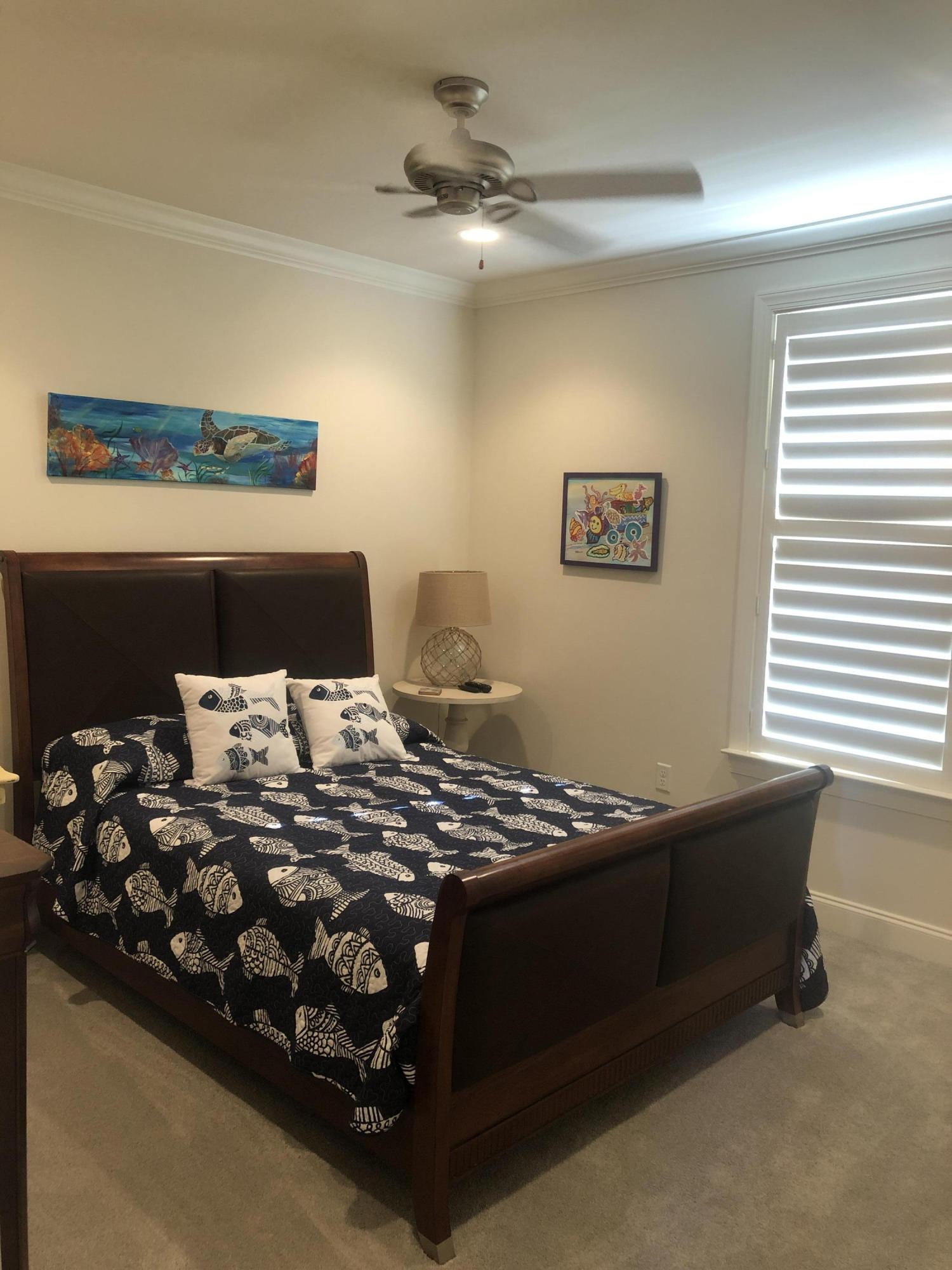 52 Chapman Street Santa Rosa Beach, FL 32459 - Photo 29 of 50 a bed sitting in a bedroom next to a window with a chandelier