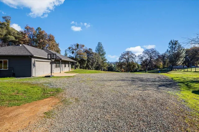a view of a house with backyard and trees