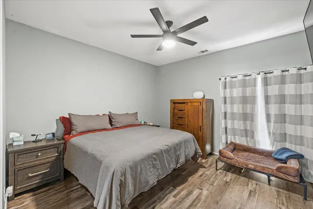 a bedroom with a bed and wooden floor