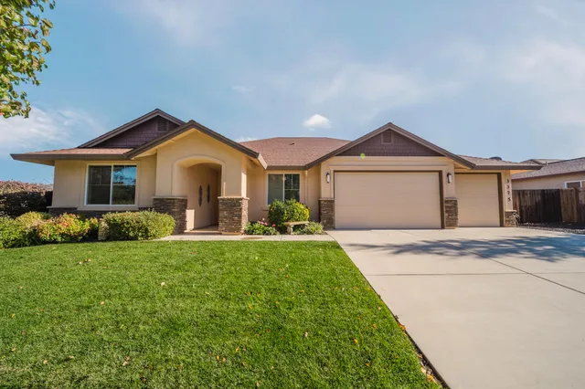 a front view of a house with a garden and yard
