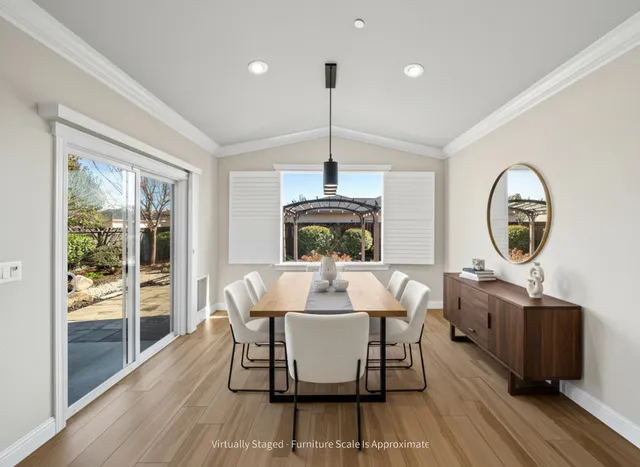 a dining room with furniture a chandelier and wooden floor