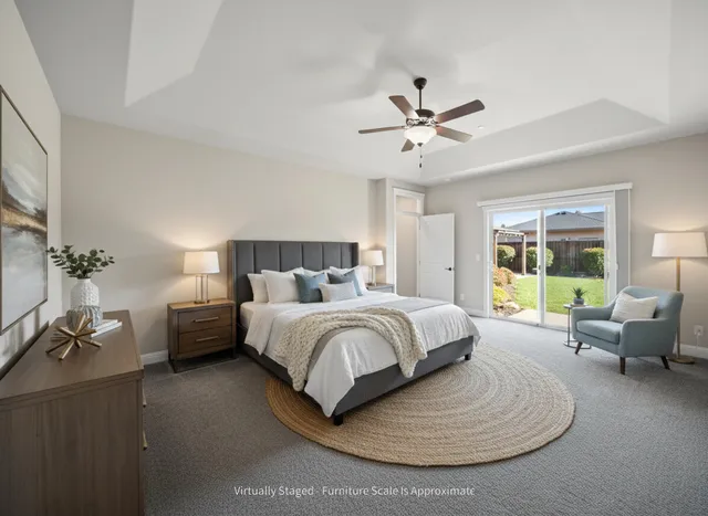 a spacious bedroom with a bed a couch and a chandelier